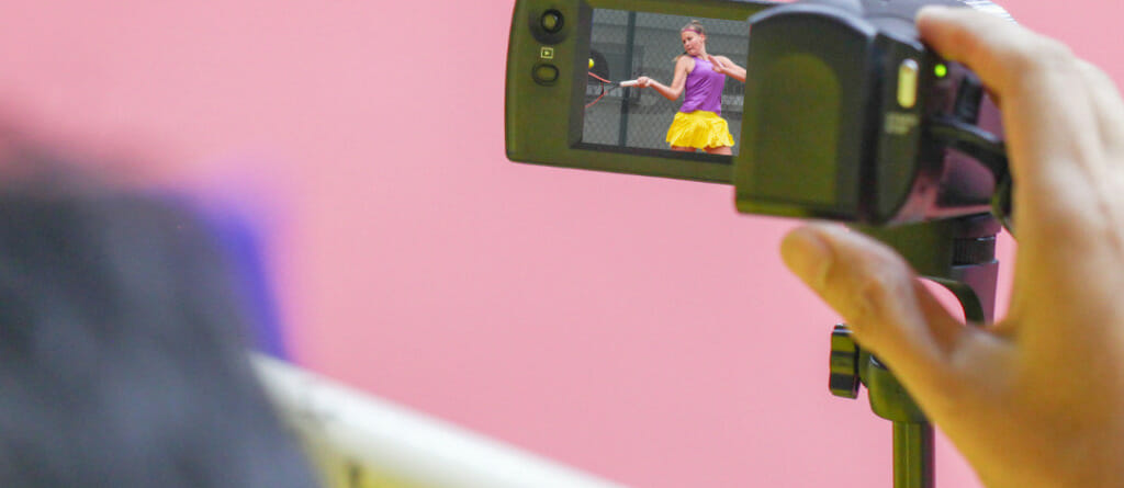 Filming a girl playing tennis with a camera to get tennis tips from coaches.